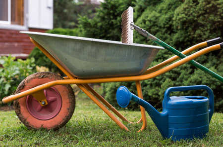 Preparing the garden for autumn and winter. Closing the summer season. A garden wheelbarrow, rake,...