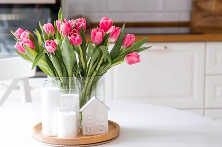 The concept is timed to the arrival of spring and International Women's Day on March 8. A bouquet of spring, delicate, pink tulips in a beautiful stylish vase on the table.の写真素材