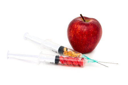 Juicy red apple and syringes with vitamins and chemicals の写真素材