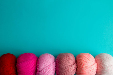 Acrylic balls of yarn on a blue background. A nuanced combination of colors. The skeins are located...