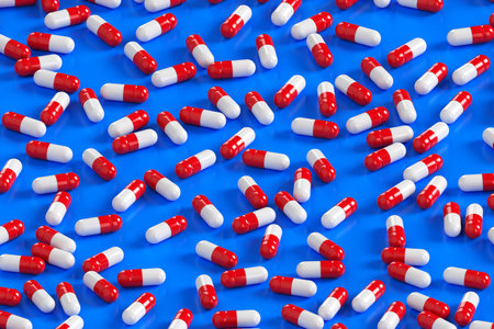 Background from red-white capsules on a blue surface. Production of drugs. Medical theme. 3d...