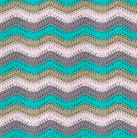 Seamless knitted pattern in the form of zigzags is crocheted with multi-colored threads. Acrylic...