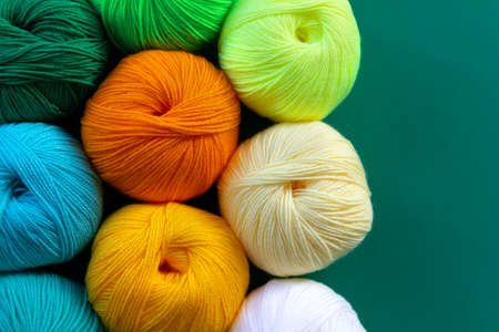 Background of stacked skeins of acrylic yarn. textile industry. Arranged balls of yarn. natural and neon colors.の写真素材