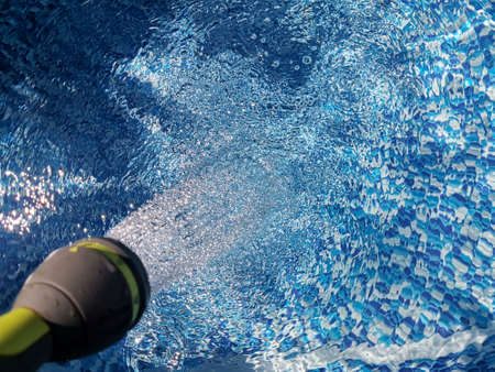 Inflatable pool with water. A set of water in the pool from a hose. blue background. Pool view from above.の写真素材