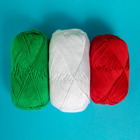 Skeins of cotton yarn are folded according to the colors of the Italian flag. view from above. materials for knitting. textile industry. Arranged balls of yarn.の写真素材