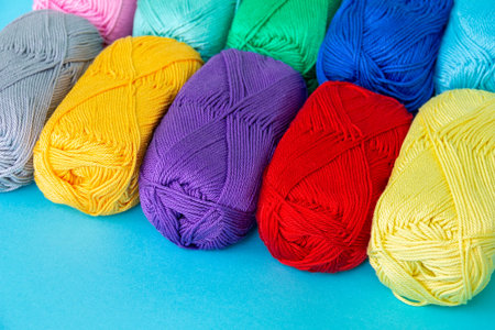 Colorful multi-colored skeins of cotton yarn are folded in a row at an angle. materials for knitting. textile industry. Small depth of field.の写真素材
