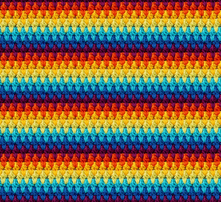Seamless knitted texture in afghan style. The pattern is crocheted from multicolored cotton yarn. textured blanket.の写真素材
