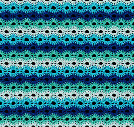 Seamless knitted texture in the form of the sun. The pattern is crocheted from multicolored cotton yarn. Bright summer range of shades.の写真素材