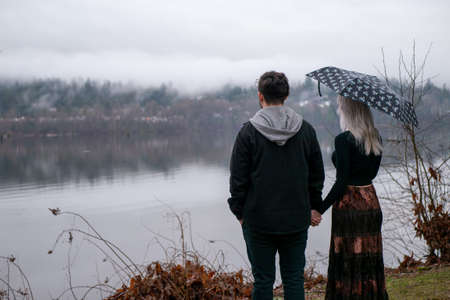 Couple sticking together on bridge and enjoying the viewの写真素材