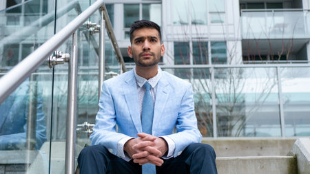 Middle Eastern businessman sitting on stairs looking to the future