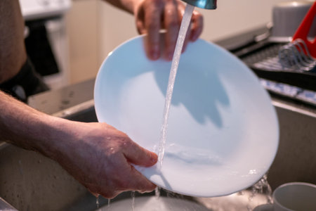 Man's hand washing dishes