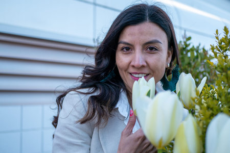 Mexican woman's side face appreciating brightly colored tulips