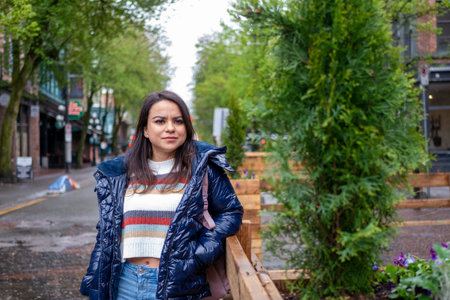 Mexican woman sightseeing in downtown Vancouver in the rain