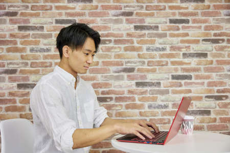 Man working on laptop in cafÃ© spaceの写真素材