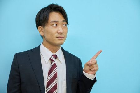 Asian man pointing to blank space