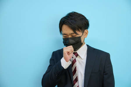 Asian man coughing with a mask onの写真素材