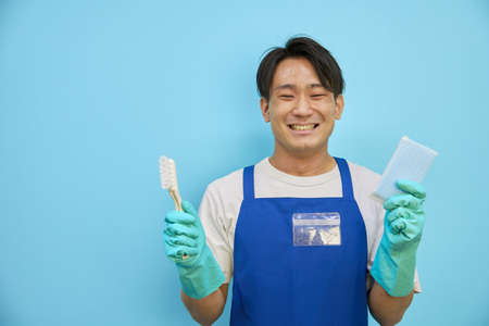 Japanese man smiling with cleaning equipmentの写真素材