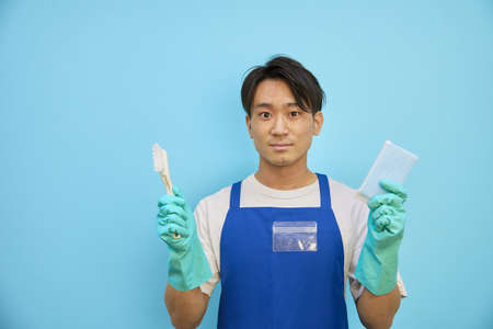 Japanese man smiling with cleaning equipmentの写真素材