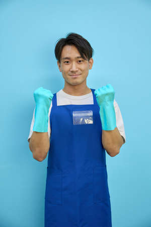 Asian man cleaning in rubber glovesの写真素材