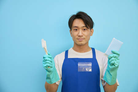 Japanese man smiling with cleaning equipmentの写真素材