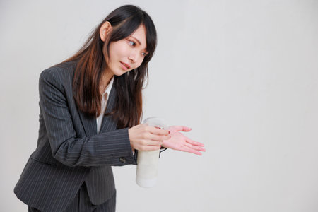 Businesswoman in a suit who sprays disinfectant sprays on othersの写真素材