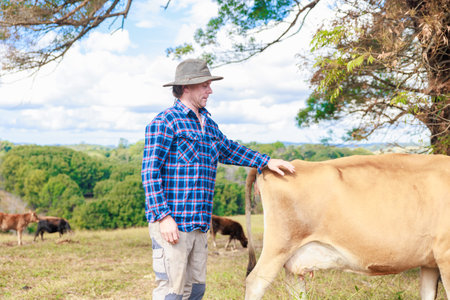 Farmer with a cow in the pasture. Cattle breeding.の写真素材