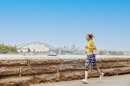 Young woman jogging on a sunny day in Sydney, Australia.の写真素材