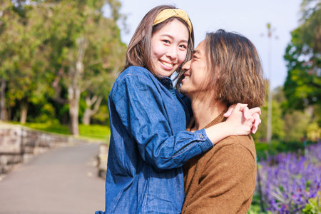Mother and daughter kissing in the park. People, relationship, lifestyle concept.