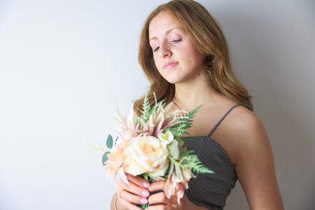 Portrait of a beautiful young woman with a bouquet of flowersの写真素材