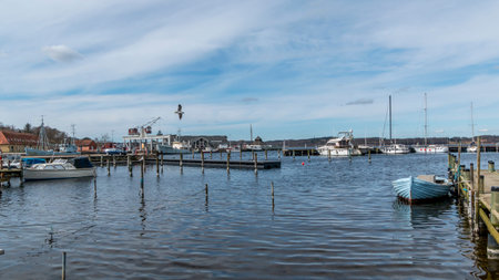 Mariager, Denmark - 29 march 2020: Scene from a Danish marina with view past yacht to houses by the...