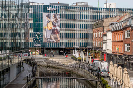 aarhus, Denmark - 24 march 2020:  Promenade along the river Aarhus A in the city center of the town of Aarhus. Stores and offices on both sides, Magasin Shopping center in the backgroundのeditorial素材