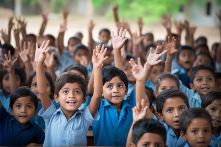 Group of school children raising their hands in the classroom. Education concept.の素材