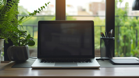 Laptop computer with blank screen on wooden table in coffee shop.の素材