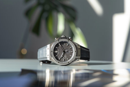 Men's wrist watch on a table in a room with a plantの素材