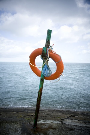 A lifesaver on a pole on a gray and stormy dayの写真素材