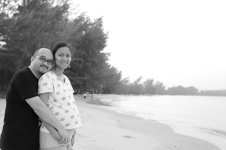 A man hugs pregnant woman on the beachの写真素材