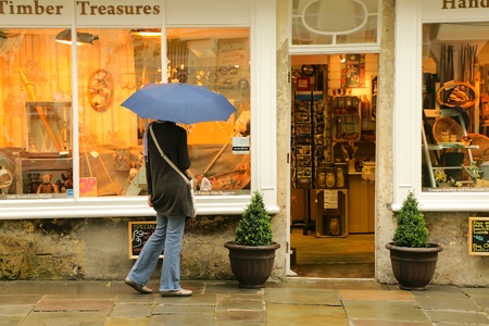 A lady with umbrella looks at antique shopのeditorial素材