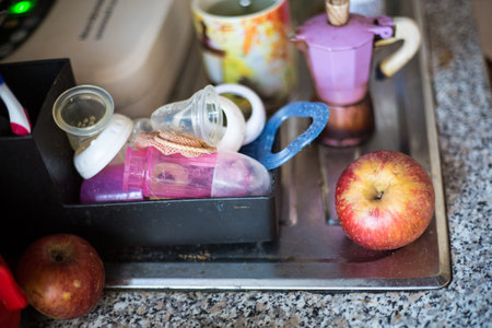 Kitchen still-life with red apple anurca, baby feeding staff and coffee machine mocca with a cup in...