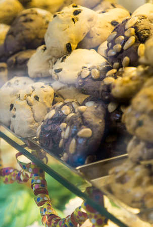 Many white and chocolate round biscuits with nuts on top. Pastry counter with fresh cookies. Traditional italian Venetian sweets. carbohydrate food. Gluten free pastry shop. Italian dessertsの写真素材