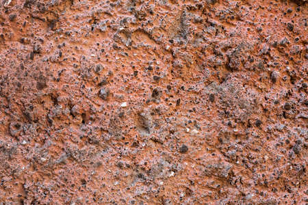 Pale orange plaster on exterior cement wall with small stones. Background snd Wallpaper textured picture. top view. Paints and varnishes. Nobody. Copy and test space. Aged wall pattern. Construction work photoの写真素材