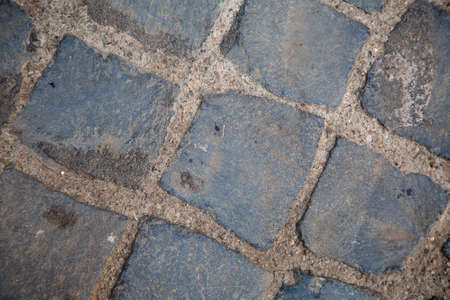 top view to grey square cobblestone pavement. Diagonal geometric composition. Street surface. Wallpaper and background picture. traditional italian anti-seismic historical wall. Stone bricks.の写真素材