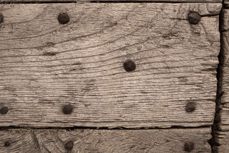 Sample of old door with big metal nails. Closeup of antique mediterranean wooden gate. Background and wallpaper picture. Copy space. Vintage surface. rusty iron rivets. Ageing concept.の写真素材