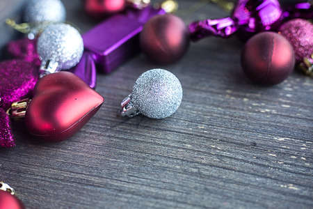 Many small red and silver decorations for Christmas tree. New year toys, hearts and balls on wooden grey surface. Flat layer composition for winter holiday card. Invitation background. Tender and love concept. . High quality photoの写真素材