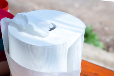 A roll of toilet paper is currently sitting on a wooden table surfaceの写真素材