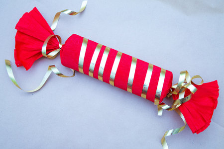 A delightful candy with red and gold stripes and a gold ribbonの写真素材