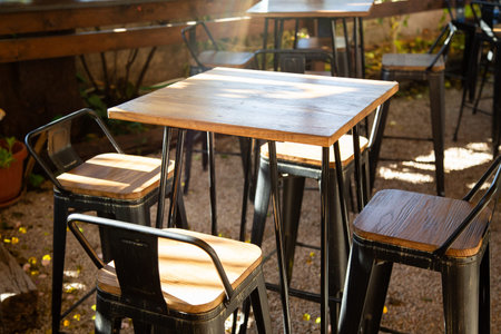There is a long row of tables and chairs set up outside on a sunny day