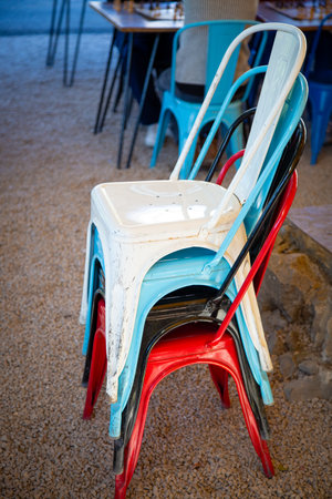 A stack of colorful chairs piled up on the groundの写真素材