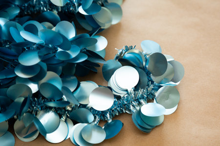There is a pile of shimmering blue and silver sequins on a tableの写真素材