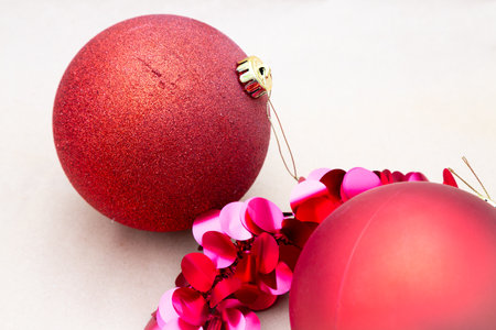 Two bright red Christmas ornaments are beautifully sitting close to each otherの写真素材