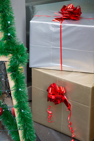 A beautifully stacked collection of Christmas presents topped with a red bowの写真素材